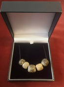 A Restrung Mammoth Bone- five Beaded Pendant.