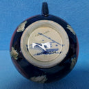 A Moorcroft Cup and Saucer in the Pansy Pattern by William Moorcroft