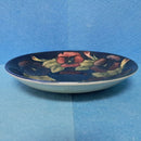 A Moorcroft Cup and Saucer in the Pansy Pattern by William Moorcroft