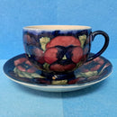 A Moorcroft Cup and Saucer in the Pansy Pattern by William Moorcroft