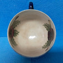 A Moorcroft Cup and Saucer in the Pansy Pattern by William Moorcroft