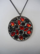 A Vintage Style Necklace with Oval and Round stones in a Circular Setting.