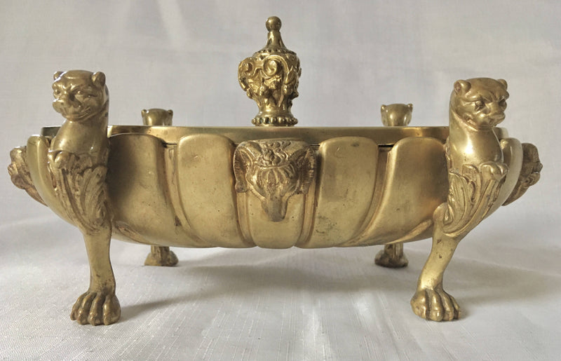 Regency period gilt bronze inkstand raised on lioness paw feet and adorned with ram masks.