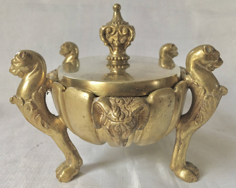 Regency period gilt bronze inkstand raised on lioness paw feet and adorned with ram masks.